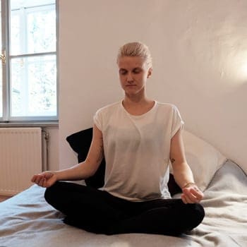 Alicia meditating in bed